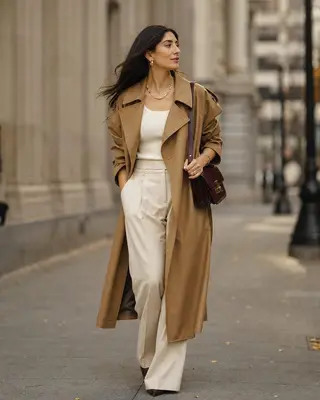 Street-style look with a camel trench coat, cream outfit and burgundy shoulder bag